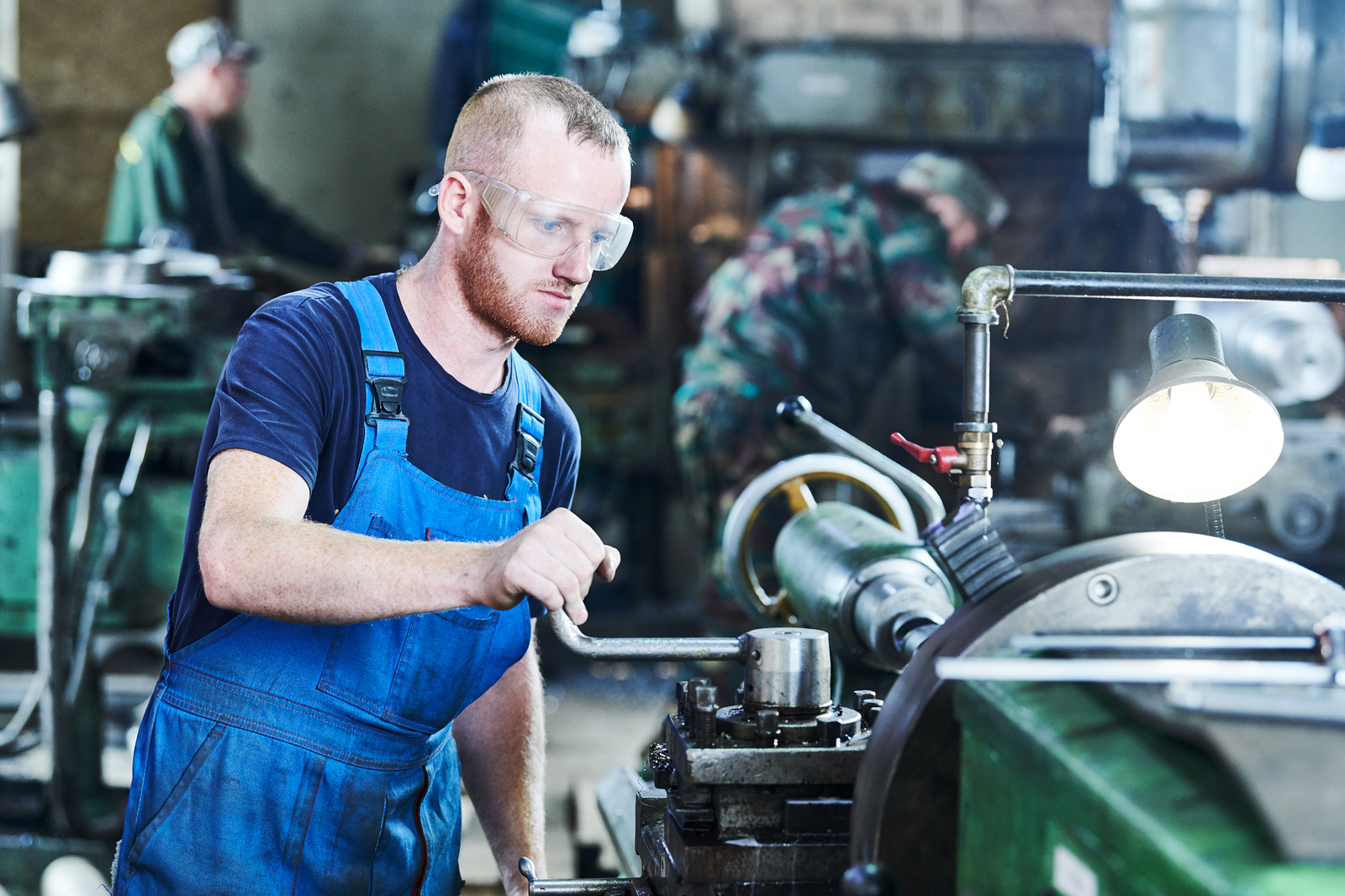 Worker turning operating lathe